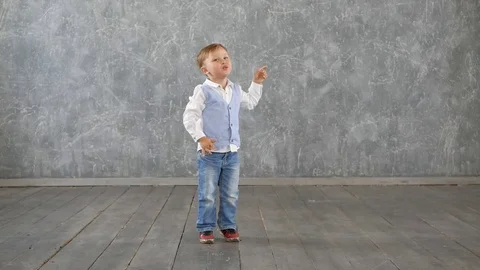 Charming little boy performs a cheerful dance, Playfully shoots at the ceiling Stock Footage 77393528
