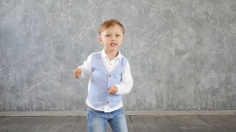 Charming little boy performs a cheerful dance Stock Footage 77395476