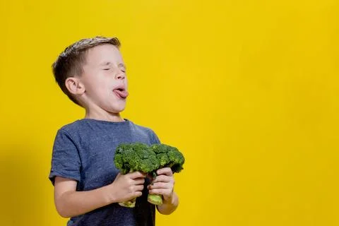 A charming little boy refusing to eat broccoli. Brootish broccoli Stock Photos