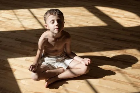 Charming little boy is while doing yoga at home Stock Photos
