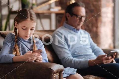 Charming little girl and grandfather demonstrating Internet addiction indoors Stock Photos