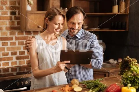 Charming lovely couple reading cooking instructions Stock Photos