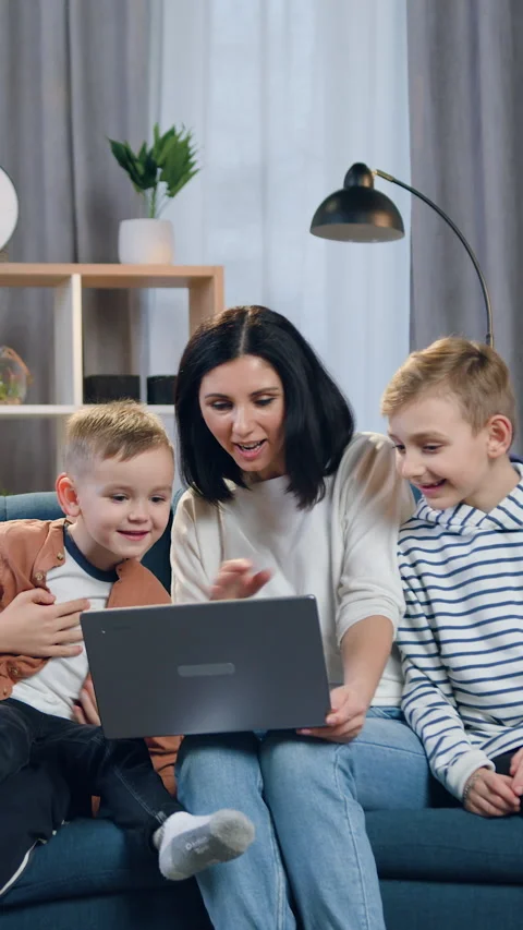 Charming loving young mom and her cheerful 2-aged,8-aged and 10-aged sons sittin Stock Footage 328709261