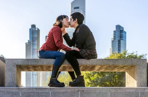 Charming low-angle view of a young couple of women sharing a loving kiss on.. Stock Photos