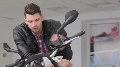 Charming man smiling while sitting on a sleek black motorbike Stock Footage 311184231