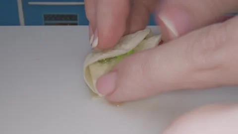 In a charming miniature kitchen hands skillfully prepare food with tiny cookware Video stock 286892351