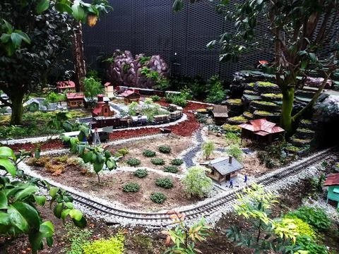 A charming miniature train set winds through a detailed landscape Stock Photos