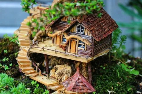 A charming miniature tree house crafted from wood, nestled amongst lush moss  Stock Photos