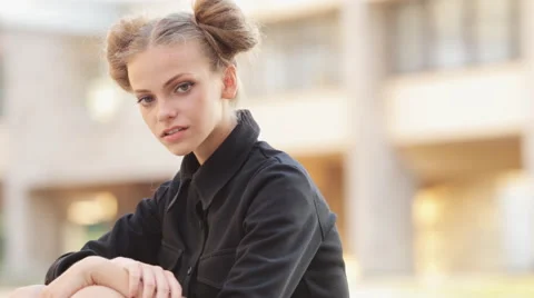 Charming model posing for the camera while sitting near the University Video stock 52923563