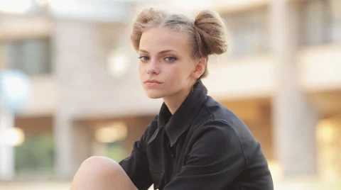 Charming model posing for the camera while sitting near the University Video stock 52923732