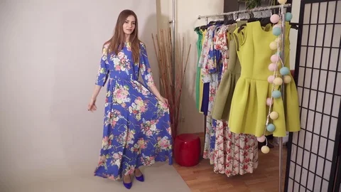 Charming model under the camera flashes presenting colored blue dress Stock Footage 74430362