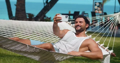 Charming multi-ethnic man on vacations, taking selfie or recording video on his Stock Footage 221703490