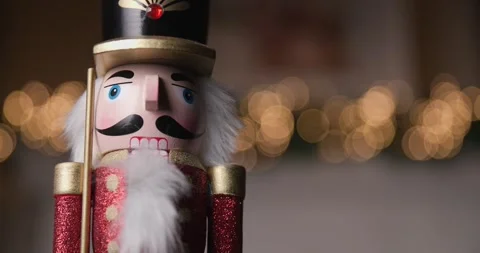 Charming Nutcracker figurine standing still in front of glowing bokeh lights, Stock Footage 287176780