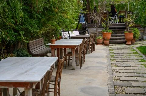 Charming outdoor dining area with rustic furniture in a lush garden setting Stock Photos
