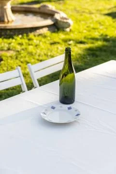 A Charming Outdoor Dining Setup Featuring a Green Bottle and Decorative Plate on Stock Photos