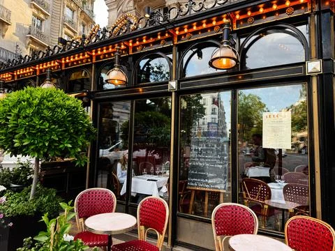 Charming Paris Le Dome cafe bistro with outdoor seating, red wicker chairs,.. 库存照片