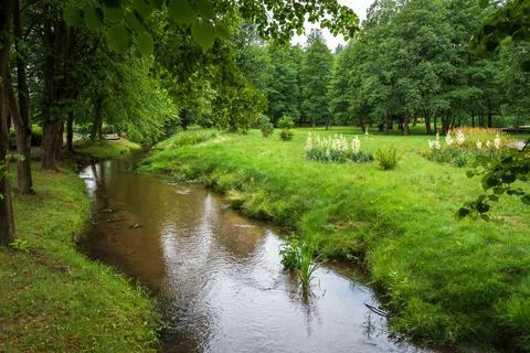 A charming river with a sandy bottom flowing through the spa park Stock Photos