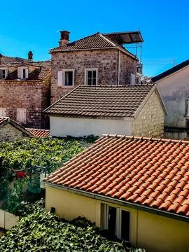 Charming Rooftops Featuring Rustic Architecture Beneath a Clear Blue Sky All Stock Photos