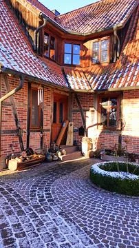 This is a charming rustic courtyard that features a lovely cobblestone pathway Foto stock