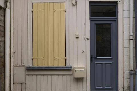 A charming rustic house facade, showcasing a beautiful shuttered window along Stock Photos