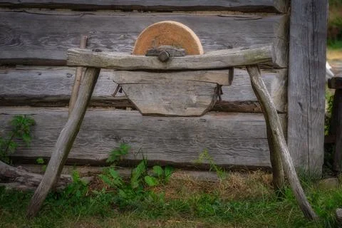 A Charming Rustic Stone Grinding Wheel Set Against a Beautiful Weathered Wood Stock Photos