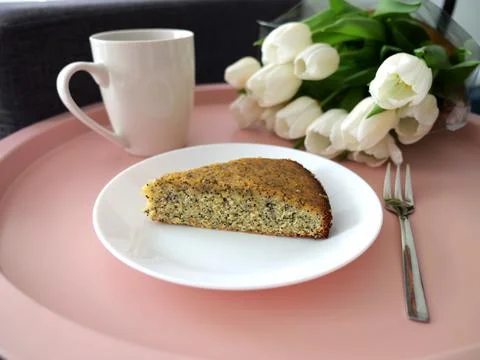 Charming scene featuring a cup of coffee, poppy seeds, and vibrant tulips Stock Photos