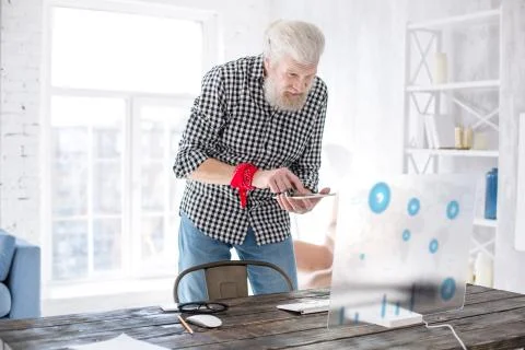 Charming senior man projecting data from tablet onto screen Stock Photos