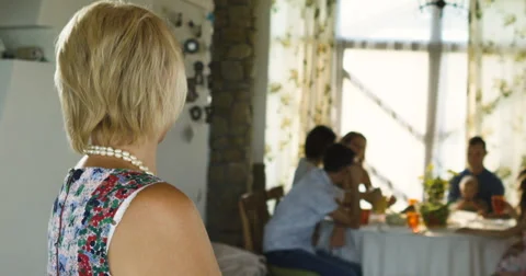 Charming senior woman posing on the camera and family sitting at dinning table Stock Footage 66289764
