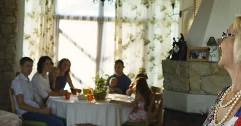 Charming senior woman posing on the camera and family sitting at dinning table Stock Footage 66289833