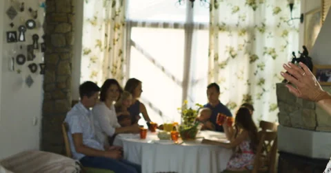 Charming senior woman posing on the camera and family sitting at dinning table Stock Footage 66289911