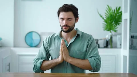 Charming serene Hispanic guy prays to God, holding hands at chin level Stock Footage 216028192