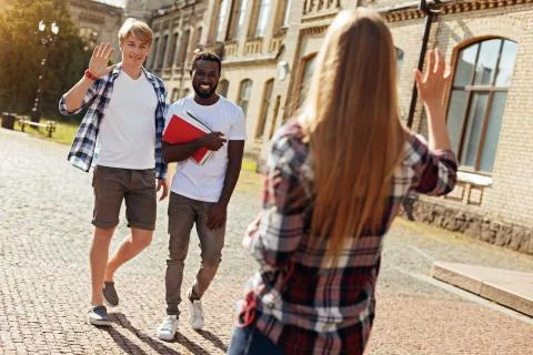 Charming sincere guys glad seeing their fellow student Stock Photos