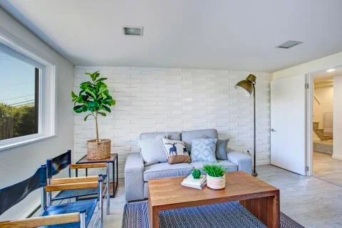 Charming sitting area with gray sofa and wood cocktail table. Stock Photos
