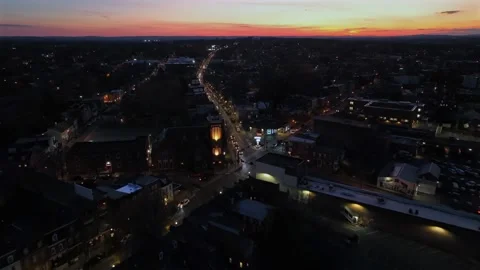 Charming small town with headlights of driving cars on street at twilight Vídeos de archivo 296722987