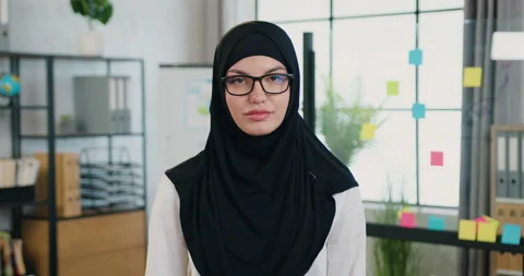 Charming smiling young successful arabic businesswoman in hijab looking into Stock Footage 159711053