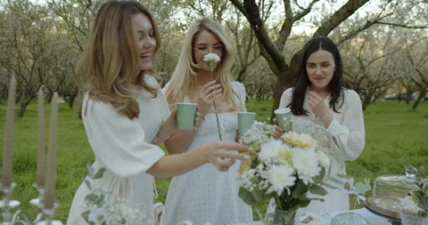 Charming Spring Gathering in a Beautiful Orchard with Elegant Attire and Joyful Stock Footage 307936436