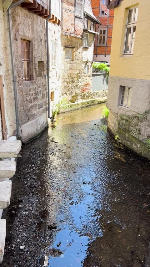 A Charming Stream Gracefully Flowing Through a Historic and Picturesque Alleyway Stock Footage 303893202