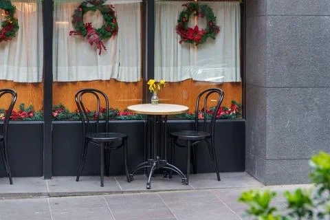 Charming Street-side Cafe Setting Featuring a Small Table and Two Chairs Ad.. Stock Photos
