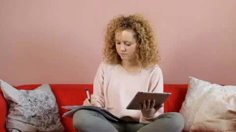 Charming student learning with notes and tablet on couch Stock Footage 22238491