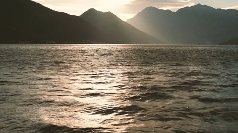 Charming sunset on a calm sea with high mountains horizon. Stock Footage 76802709