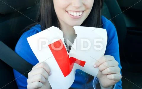 Charming teen girl sitting in her car tearing a L-sign Stock Photos