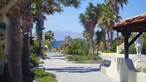 A charming vacation pathway lined with palms and greenery under the Mediter.. Stock Footage 292755743