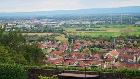 Charming village with red rooftops and church tower nestled among green fields Stock Footage 310812964