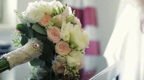 Charming wedding bouquet lying on the table, then bride takes it Video stock 67356628