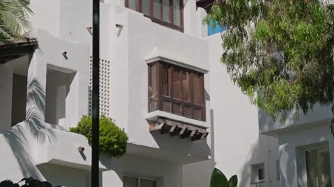 A charming white building with wooden elements, beautifully set in a vibrant Stock Footage 303703358