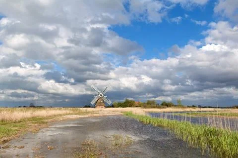 Charming windmill bu river and cblue sky with clouds charming windmill bu ... Stock Photos