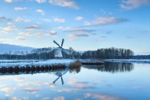 Charming windmill reflected in river water Foto stock