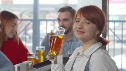 Charming woman smiling to the camera while enjoying a refreshing beer Stock Footage 311943409