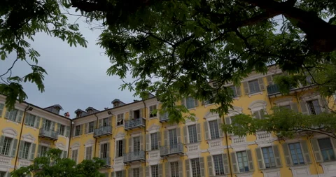 Charming yellow building surrounded by lush trees in a peaceful neighborhood at 库存影片 314076481