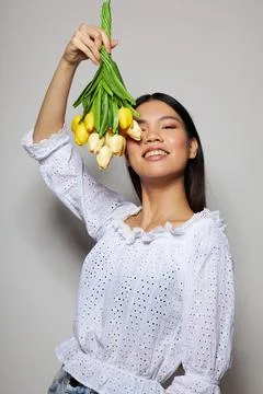 Charming young Asian woman with a bouquet of flowers smile close-up light Stock Photos